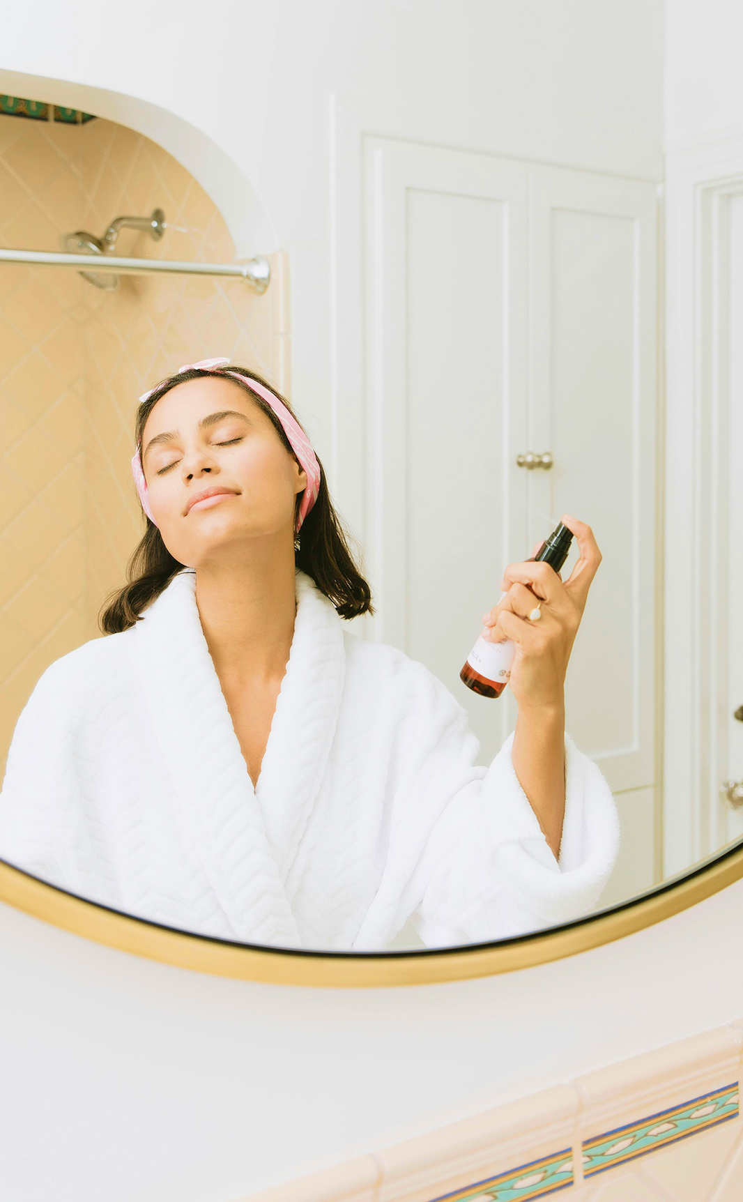 Mujer en bata en el espejo del baño
